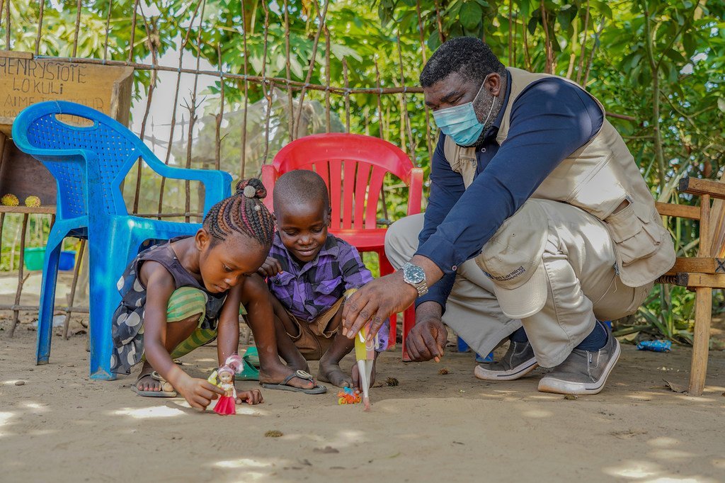 Olea Balayulu, un psychologue soutenu par l'UNICEF, tente d'aider David et Louise Ilomba, âgés de 7 et 6 ans, face à leur chagrin après la mort de leur maman à cause d'Ebola. (Equateur, RDC 2018).