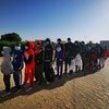 Des migrants attendent l'embarquement de leur vol de réinstallation à l'aéroport de N'Djamena. 