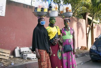 Tres mujeres con mascarilla venden medicinas en las calles de Abidjan durante la pandemia de COVID-19.