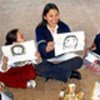 A volunteer helps children draw