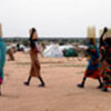 Refugee women carrying full jerry cans of water