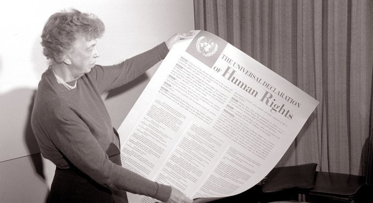 Eleanor Roosevelt tenant une affiche en anglaise de la Déclaration universelle des Droits de l'homme