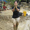 Young woman in mud-covered flooded area in Aceh