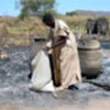 A man searches for grain in the ashes of his village