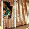 Marooned mother and child look through  window of their sunken home, Rajbari District