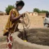 Malian woman fetches water from well