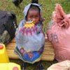 Kenyan child with her family's belongings at transit centre in Mulanda