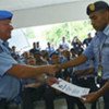 Un commandant de la police de l'ONU, David Lawry, remet un certificat à un officier du poste de police de Bidau, Gaspard Lopes, au Timor-Leste. 4 février 2008.