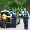 Security forces search vehicles at a check point in Dili