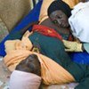 A midwife examines a pregnant woman at  a clinic