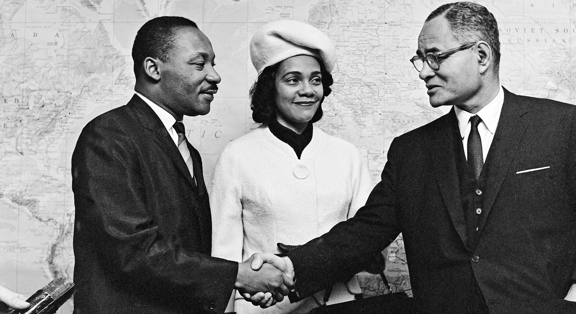 Dkt. Martin Luther King na mke wake Coretta Scott King wakionekana wakiwa wanasalimiana na Ralph J. Bunche, Msaidizi wa Katibu Mkuu wa Umoja wa Mataifa kwenye masuala ya kisiasa.  Mr.Bunche alipata tuzo ya amani ya Nobel mwaka 1950