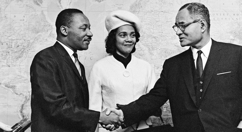 د. مارتن لوثر كينغ - ومعه زوجته، كوريتا سكوت - يصافح رالف بانش، الحائز على جائزة نوبل للسلام في عام 1950 على الوساطة في الصراع الفلسطيني.