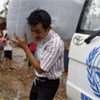 UN aid worker distributes blankets to cyclone survivors