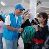 Iraqi girl receives a new school bag from UN staff in Damascus