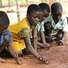 Zimbabwean children use sticks and dirt as pens and paper in an outdoor classroom near the Mozambique border