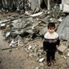 A Palestinian boy amidst the debris of a destroyed house in Gaza City