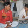 In Nayapara camp, a refugee visits community health worker Zafor Ullah (right) in his home for a fresh supply of condoms