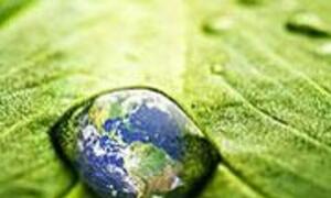 Une goutte d'eau sur une feuille verte reflète la Terre.