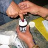 A voter's fingure is dipped in a jar of ink, a measure to prevent double voting