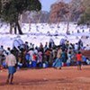 Children and adults queue for safe water near rows of tents provided by UNHCR in the conflict zone in northern Sri Lanka