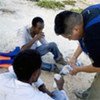 Un employé du HCR discute avec des boat people sur une plage de l'île de Lampedusa. (2007)
