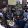 Des casques bleus népalais servent de la nourriture à des orphelins.