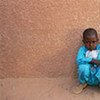 Boys sit against the wall of a UNICEF-supported health centre in Niger’s Agadez region