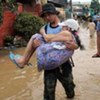 Police evacuate an elderly couple from a flooded section of a suburb east of Manila in the Philippines