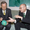 Secretary-General Ban Ki-moon signs soccer ball as Special Advisor Wilfried Lemke looks on