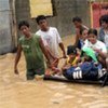 Residents use a makeshift raft to relocate children in this flooded section of Manila