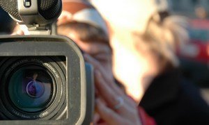 A video journalist covers a news event.