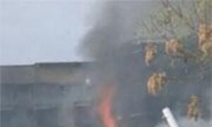 A house roof is on fire with flames and smoke rising.