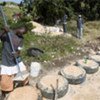 A young Haitian man using old tyres to create terracing to prevent soil erosion
