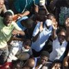 Haitians wave to a departing US helicopter after it delivered food and water.