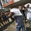 Des Haïtiens recevant des sacs de nourriture.