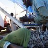 A doctor examines a pregnant Haitian woman living in a tent inside Port-au-Prince's National Stadium