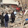 People walking in the ruins of collapsed houses after a quake in northwest China's Qinghai Province, 14 April 2010