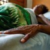 HIV/AIDS patient lies in bed at a clinic.