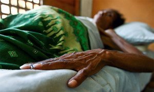 HIV/AIDS patient lies in bed at a clinic.