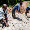 Workers use rubble from the earthquake to repair roads and build walls to protect farms from flooding