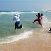 Children race into the sea near Gaza City