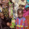 Un enfant au Niger attendant la nourriture qui l'empêchera d'être victime de malnutrition.