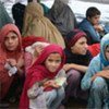 Crianças deslocadas aguardam pacotes de comida do Ramadã no acampamento Jalozai, no Paquistão
