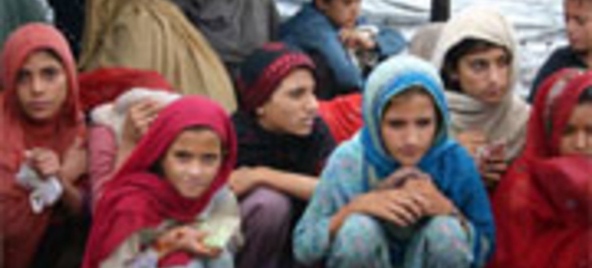 Crianças deslocadas aguardam pacotes de comida do Ramadã no acampamento Jalozai, no Paquistão