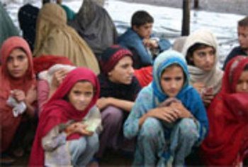 Crianças deslocadas aguardam pacotes de comida do Ramadã no acampamento Jalozai, no Paquistão