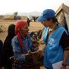 A UNHCR staff member chats to a woman displaced by fighting in Yemen.