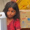 A young Pakistan girl gets foods and water from WFP