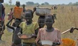 Children in a rural African landscape carry bowls and containers on their heads, likely collecting water or food.