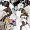 A baby and other patients suffering from acute diarrhoea lie on the floor of St. Nicholas Hospital in Haiti