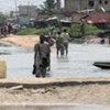 Victims of torrential rains in Benin, residents trudge through water-filled streets